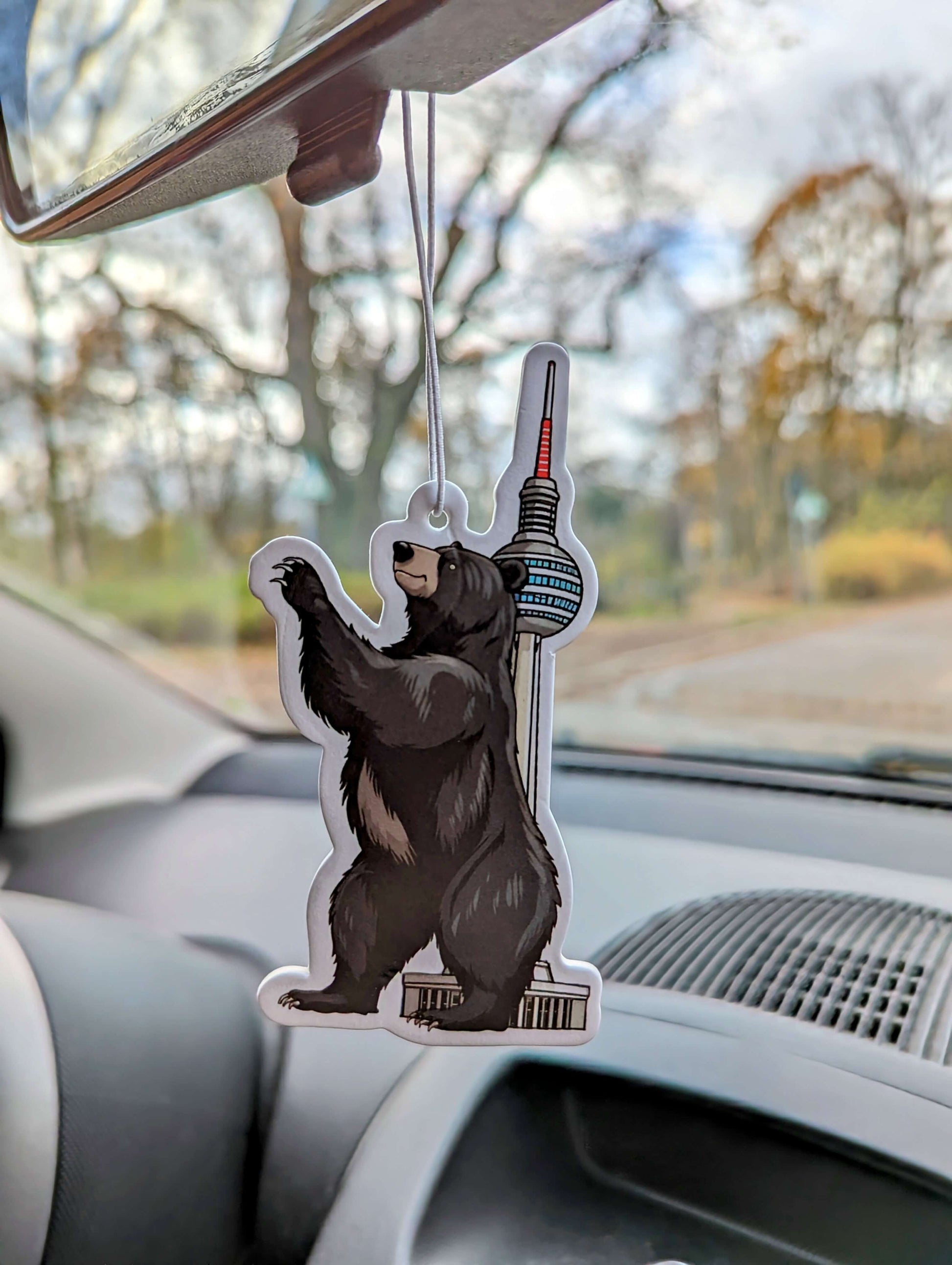 Auto Duftbaum Berlin Bär vor dem Berlin Fernsehturm und hängt am Auto Rückspiegel