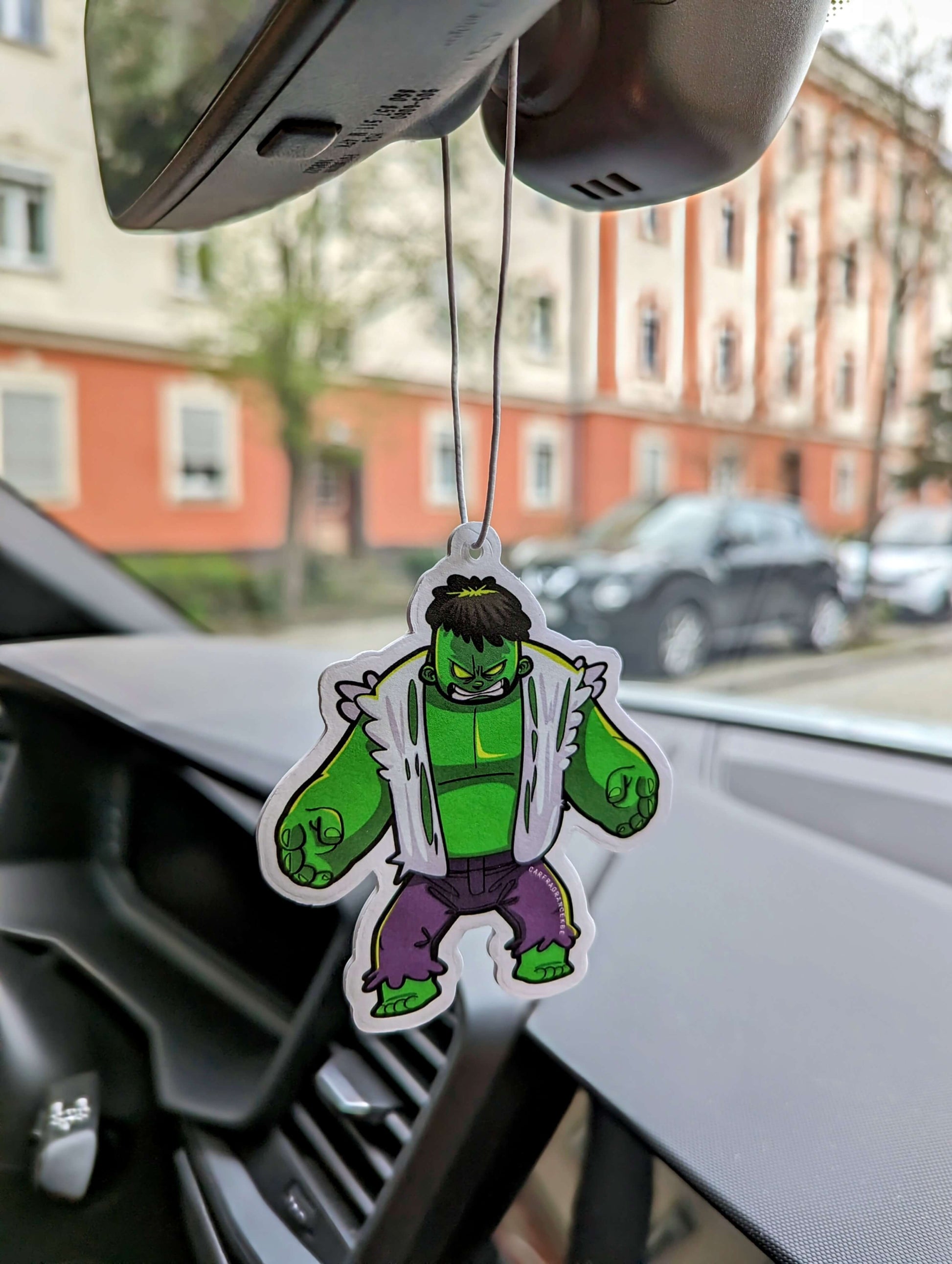 Auto Duftbaum Green Hero mit Hose und zerrissenem Hemd hängt am Auto Rückspiegel