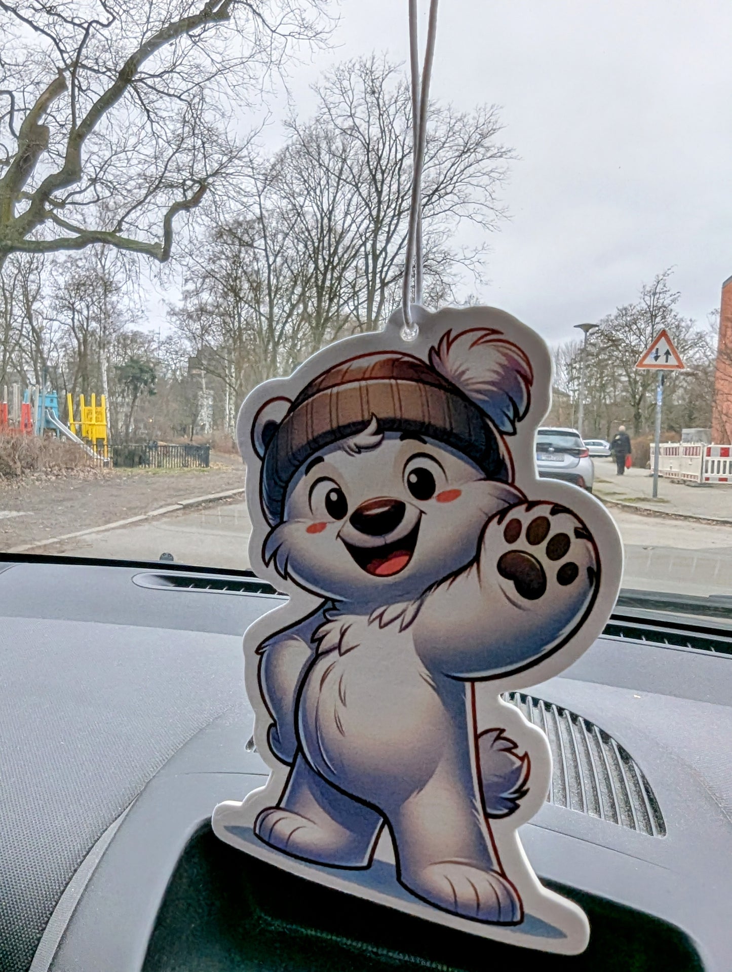 Auto Duftbaum in Form eines fröhlichen weißen Bären mit Mütze, der lächelnd die Pfote hebt, Lufterfrischer fürs Auto mit Tiermotiv, dekorativer Autoduftbaum als Geschenkidee.