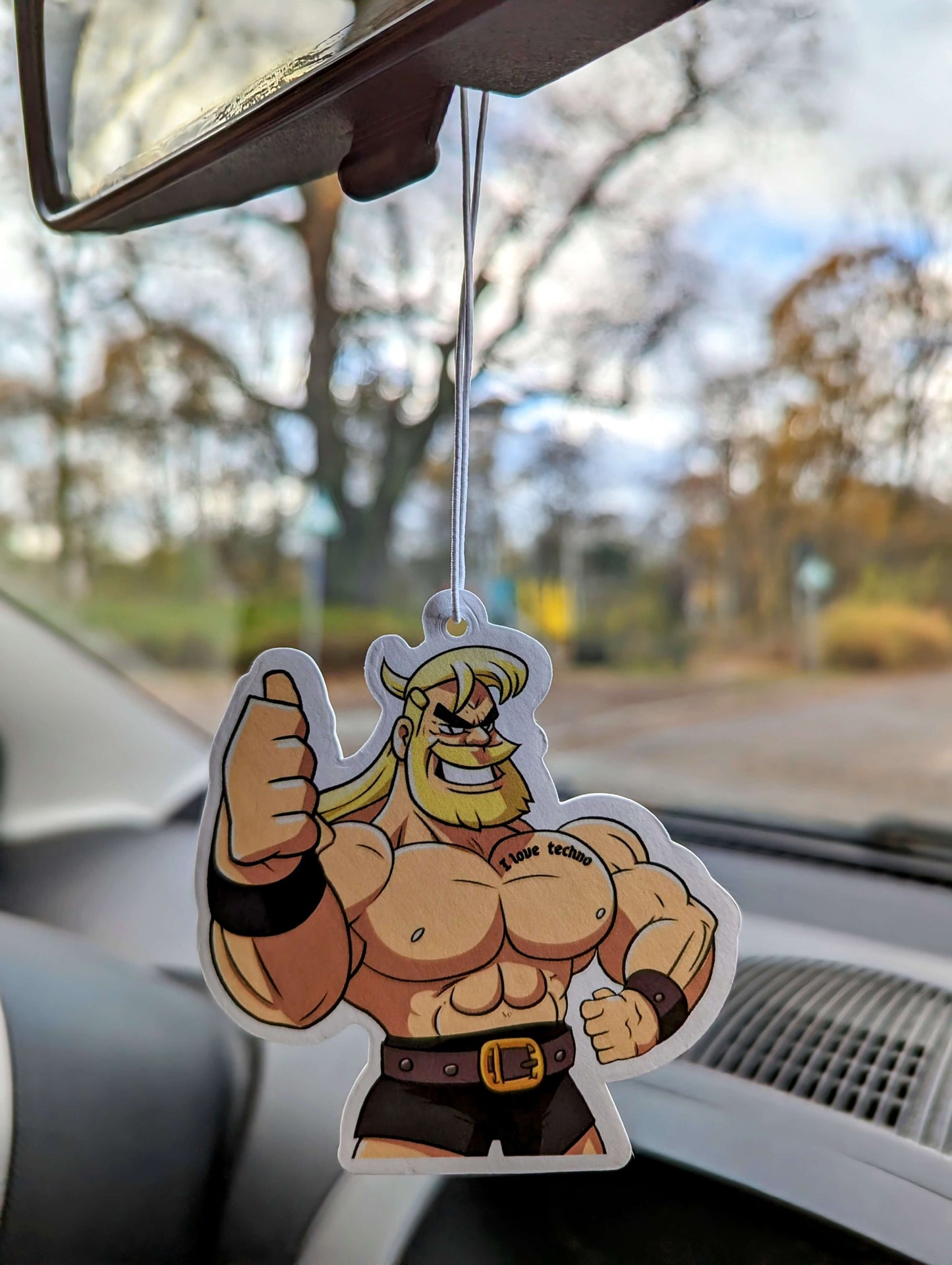 Auto Duftbaum Techno Viking mit Gürtel und kurzer Hose hängt am Auto Rückspiegel