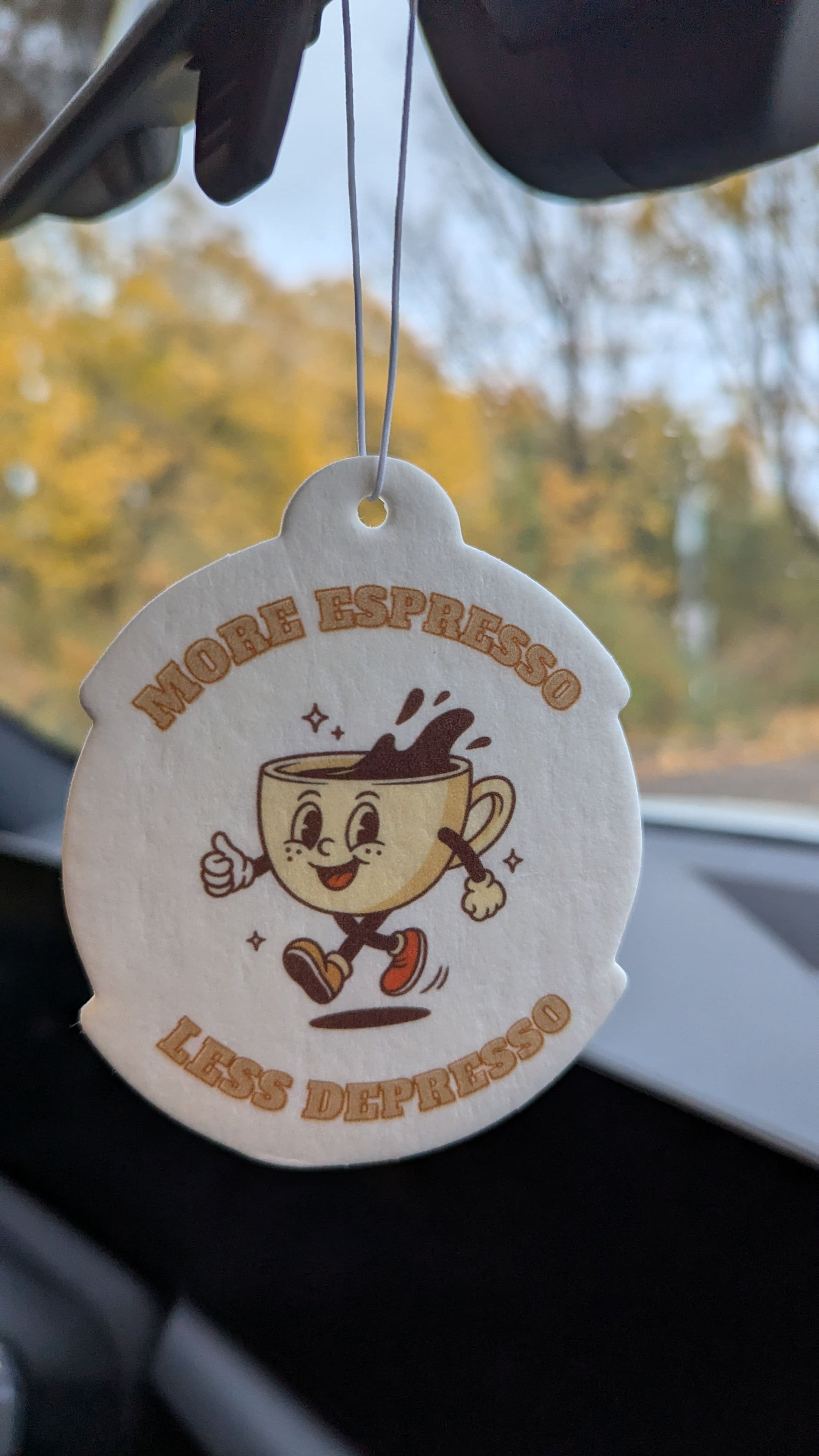 Kaffee Auto Duftbaum „More Espresso Less Depresso“ als origineller Autoduft am Rückspiegel eines Fahrzeugs aufgehängt