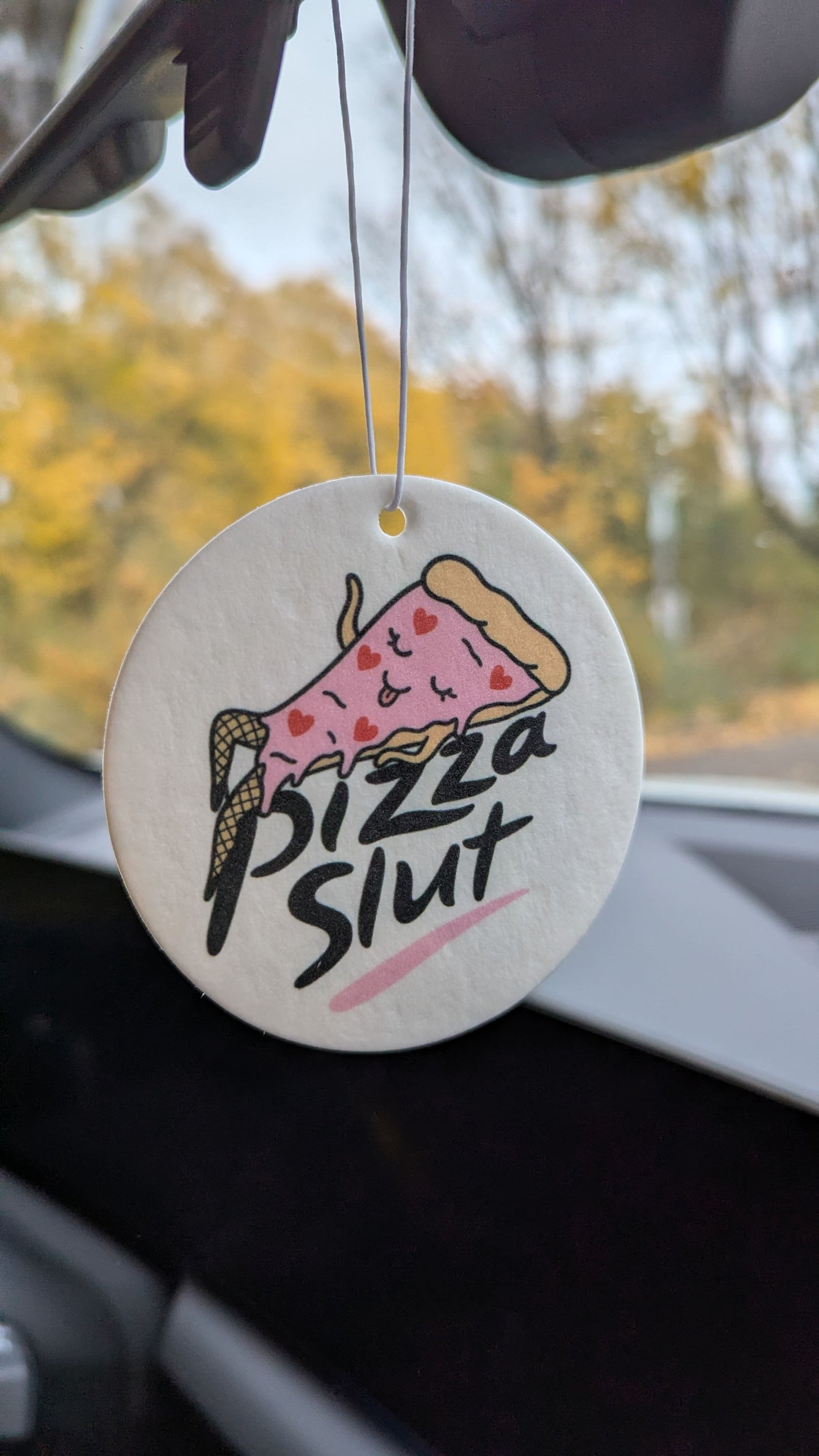 Runder Pizza Auto Duftbaum „Pizza Slut“ als ausgefallener Lufterfrischer im Auto aufgehängt